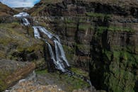 瀑布顺着郁郁葱葱的绿色环绕的岩石峡谷悬崖倾泻而下，景象令人叹为观止