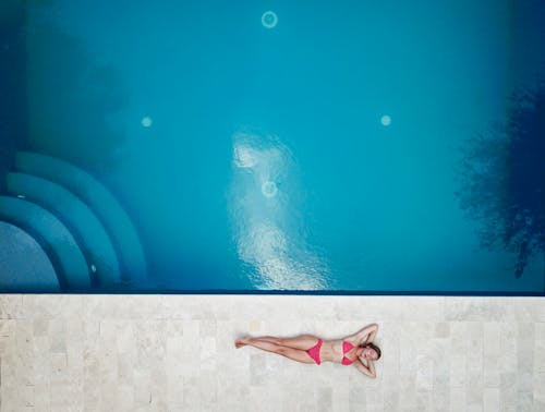 gratis Vrouw Liggend Op De Vloer In De Buurt Van Zwembad Stockfoto