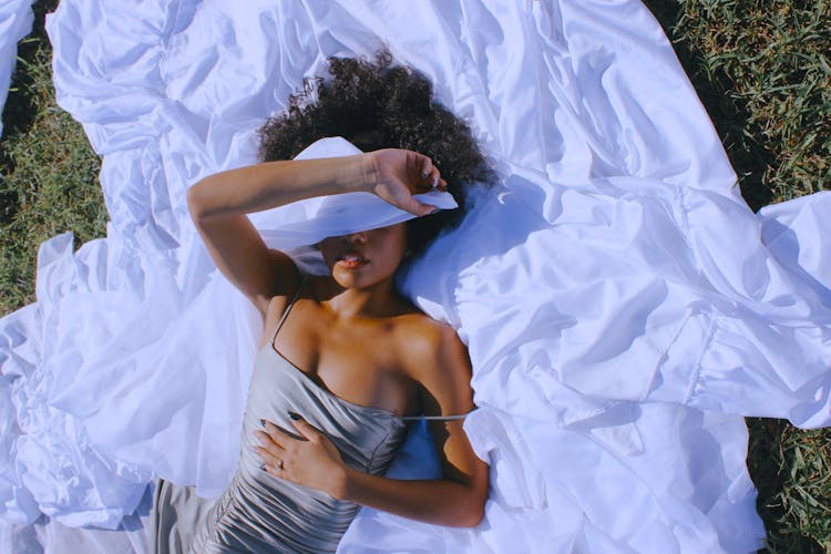 Woman Lying Down And Covering Face With White Fabric