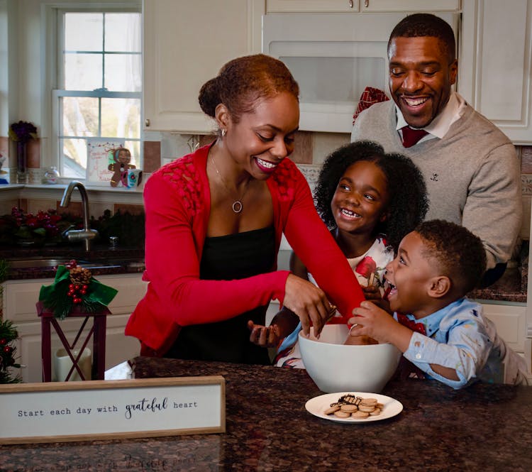 A Happy Family Having Fun Preparing Cookies In The Kitchen