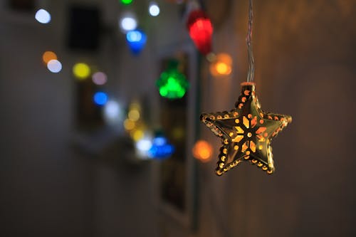Close-up of a Star Christmas Bauble on the Background of Colorful Lights 