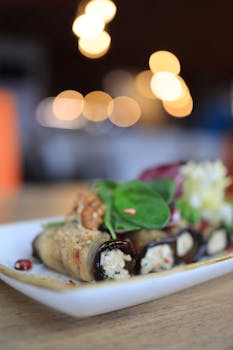 Close-up of delicious cheese-stuffed eggplant rolls garnished with greens, perfect for culinary websites.