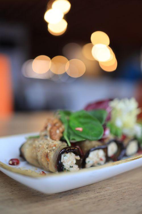 Free Close-up of delicious cheese-stuffed eggplant rolls garnished with greens, perfect for culinary websites. Stock Photo