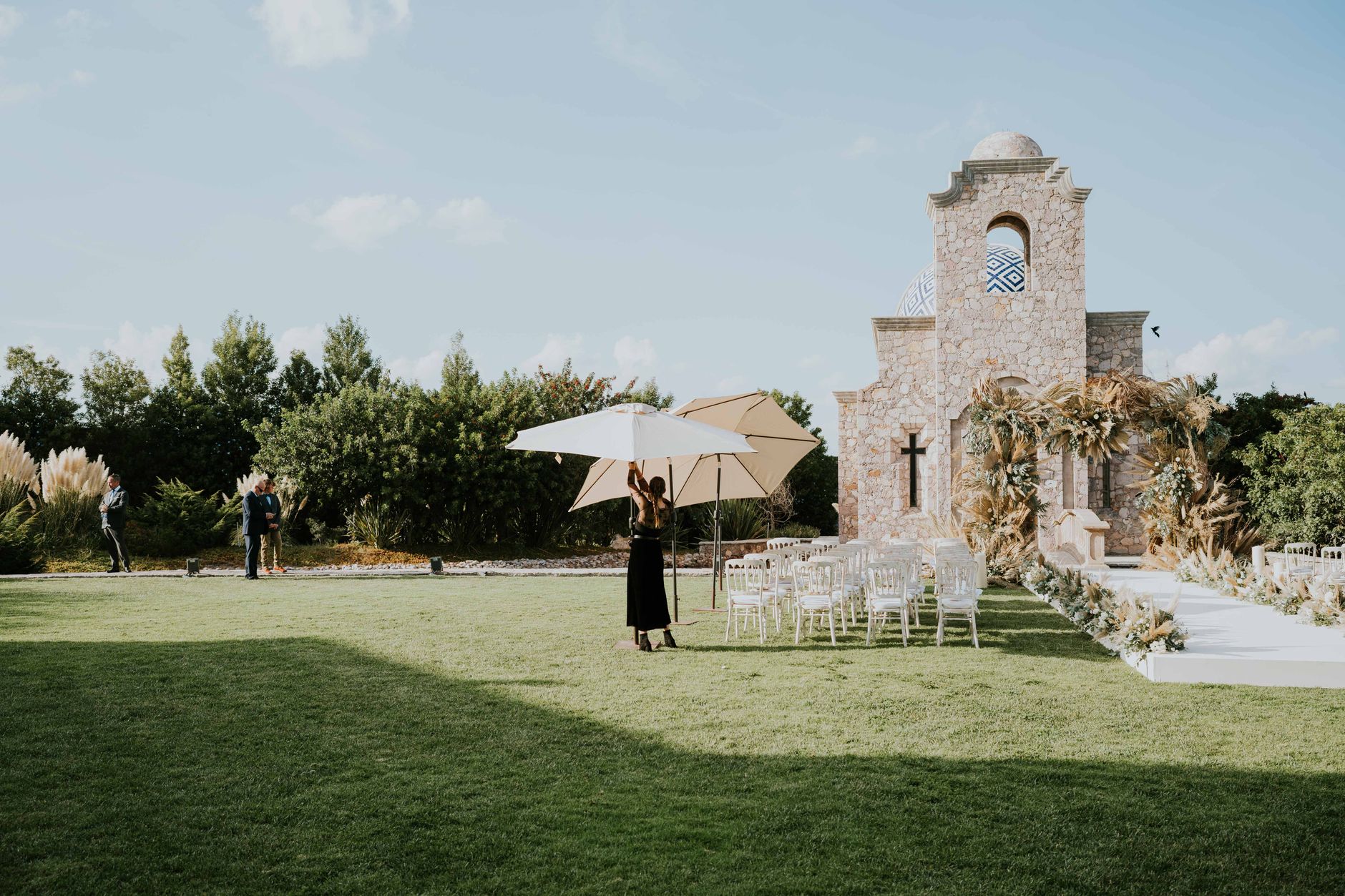 hacienda white summer party — Charming outdoor wedding setup with chairs and chapel in sunny garden.
