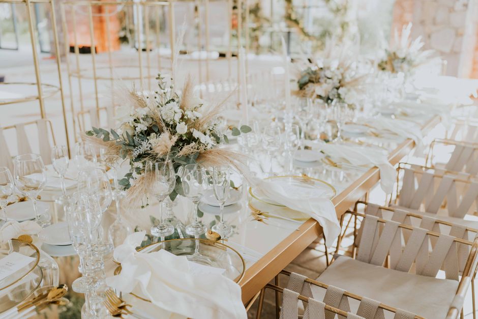 Luxurious wedding reception table with white floral centerpieces and elegant tableware.