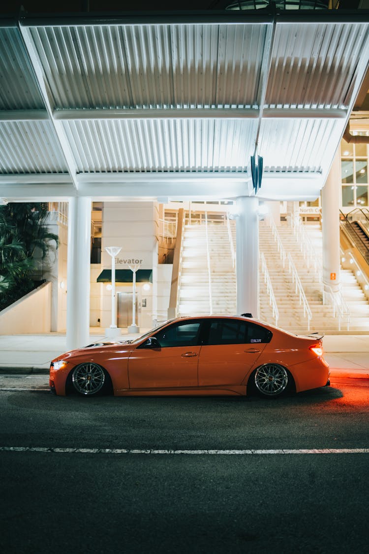 Red BMW Near Stairs At Night