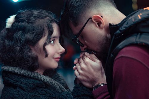 Free A couple shares a tender moment in Mashhad at dusk, highlighting affection and connection. Stock Photo