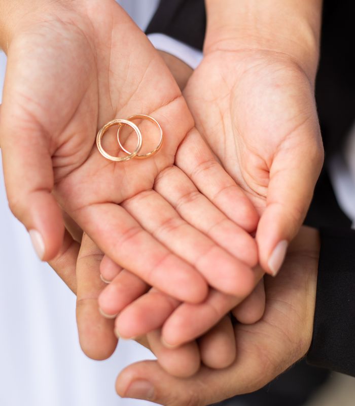 Mãos de um casal com alianças de casamento