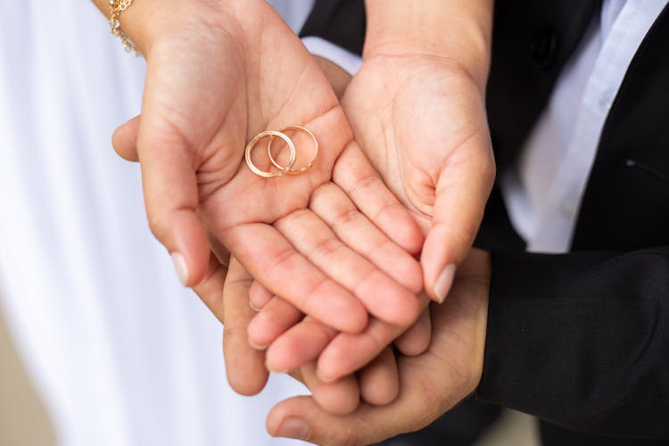 Hands Of A Couple Holding Wedding Rings