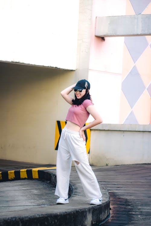 A Woman in Pink Crop Top and Jogging Pants Posing at the Camera