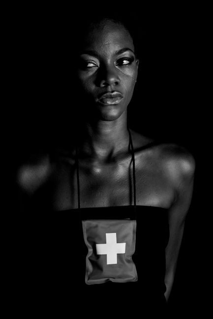 Black and white portrait of a woman with a first aid theme, dramatic lighting and expression.