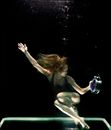 Woman Underwater Holding Round Gray Clock