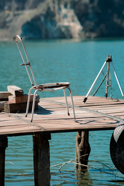 Old Chair and Tripod on Wooden Pier