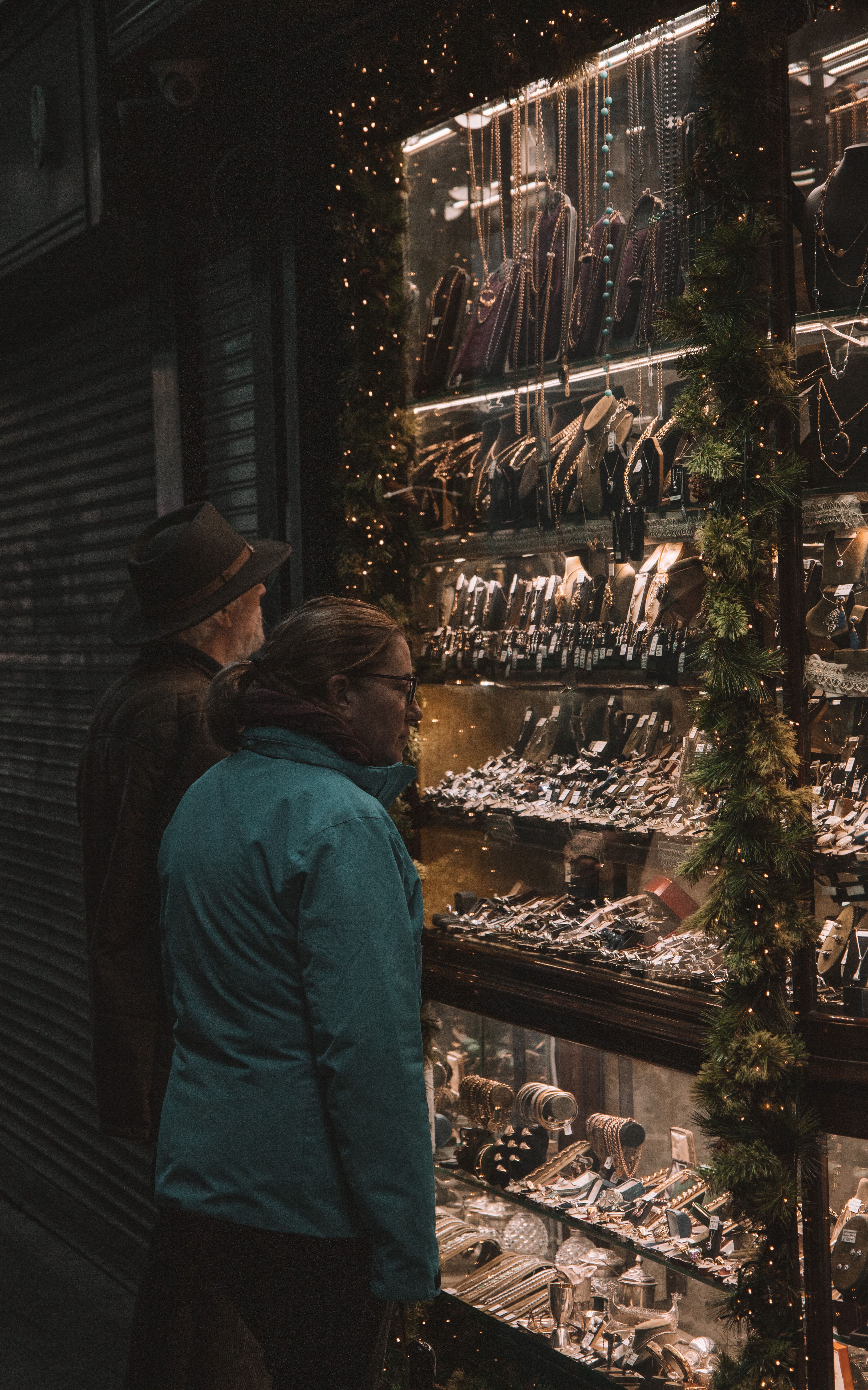 A couple admires jewelry in a beautifully lit shop window on a nighttime stroll in Dublin.