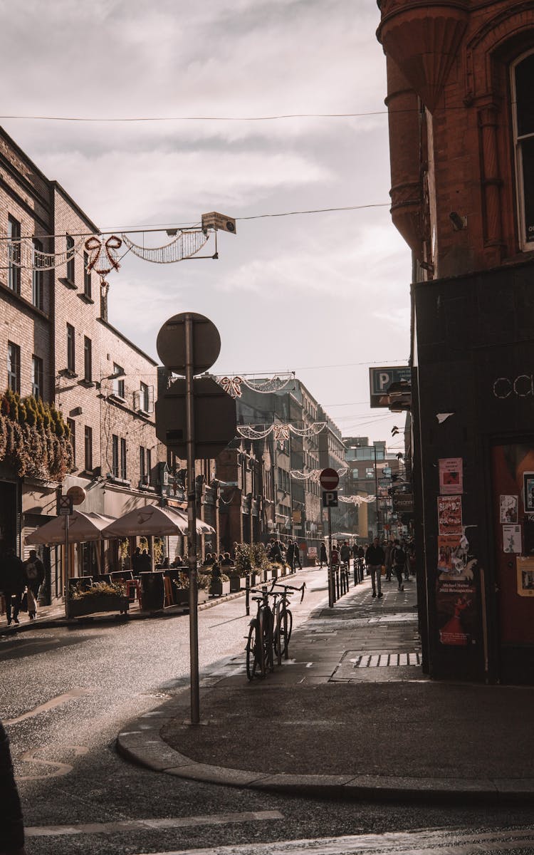 Corner Of A City Street With Christmas Decorations Hanging Between The Buildings 