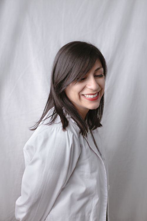 Free Adult woman in white shirt smiling, captured against a plain background. Stock Photo