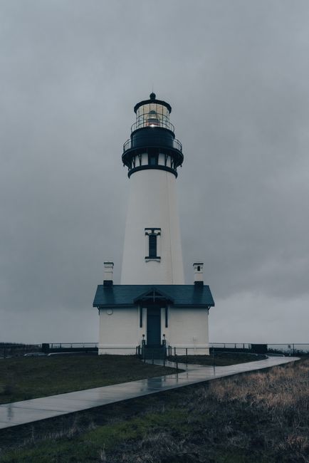 Moody view of a tall lighthouse against a cloudy sky in Newport, Oregon.