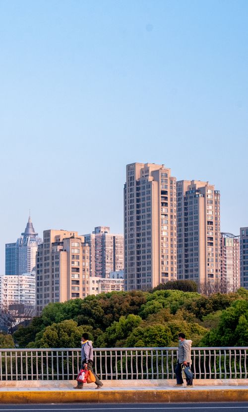 Free Cityscape of modern high-rise buildings with people walking on a bridge in daylight. Stock Photo