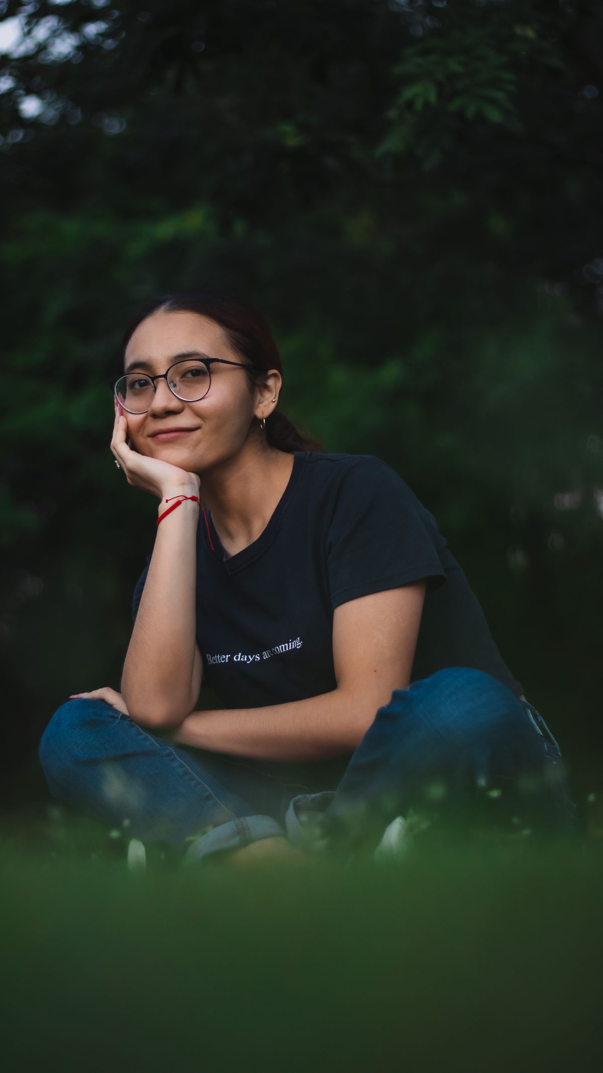 Woman wearing glasses relaxing outdoors on the grass