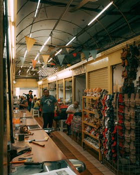 A bustling indoor market with shoe displays and people shopping, creating a warm urban environment.
