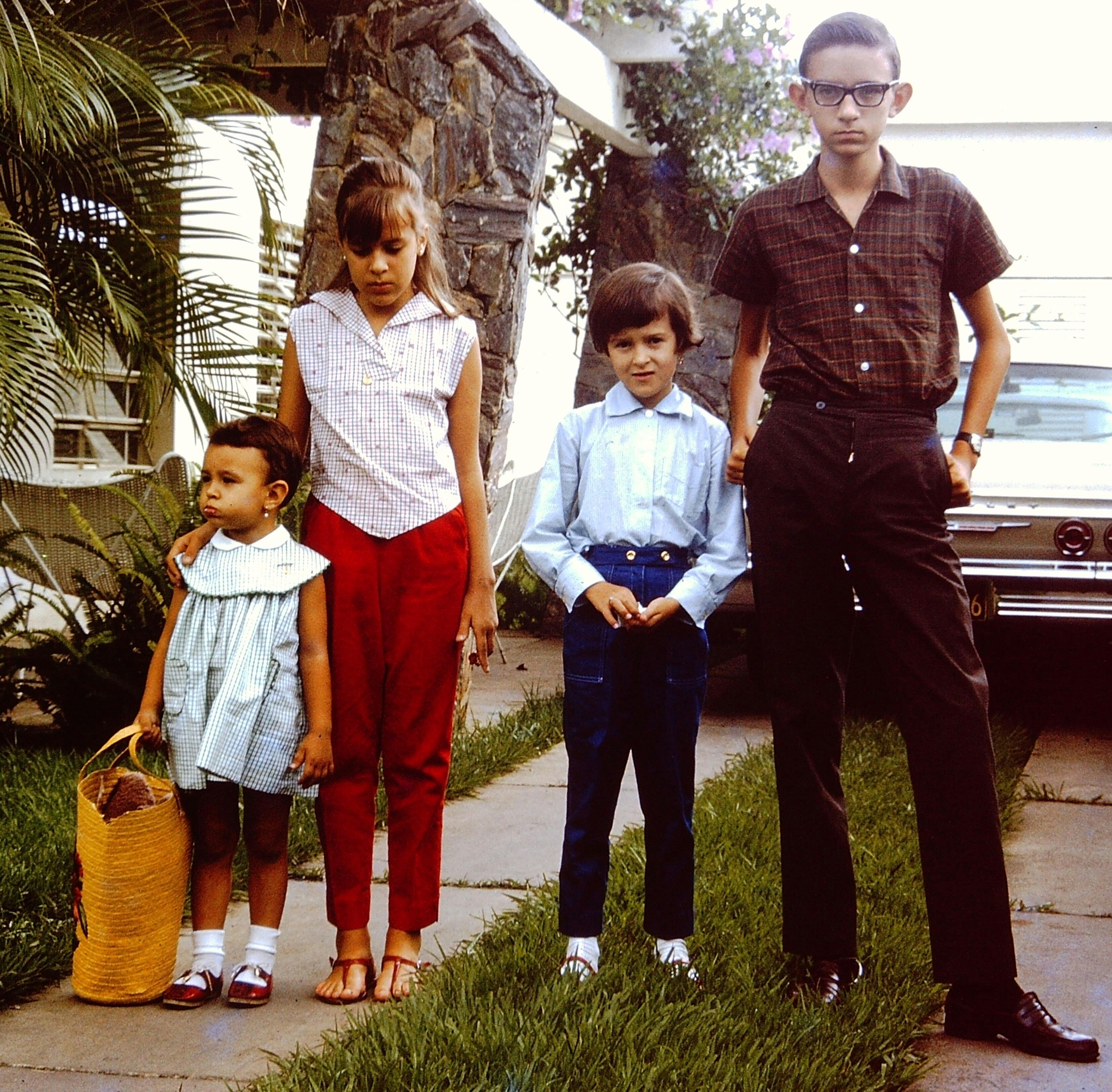 A classic family portrait with four kids posing outdoors in Valencia, Venezuela.