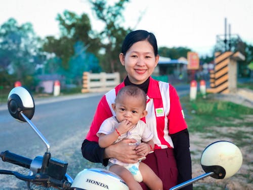 A Smiling Mother Holding Her Cute Baby