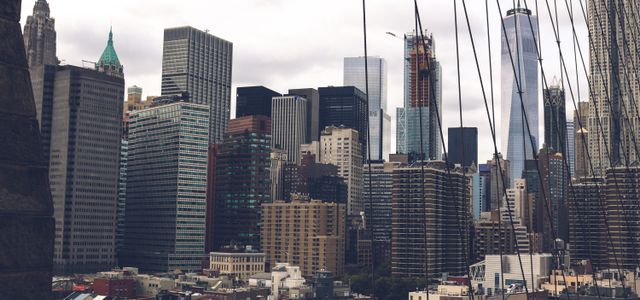 A dramatic view of the skyscrapers of New York City captured from the Brooklyn Bridge.
