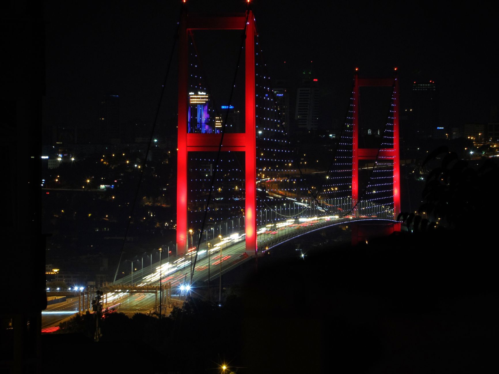 Stunning night view of the illuminated Bosphorus Bridge in Istanbul with city lights.