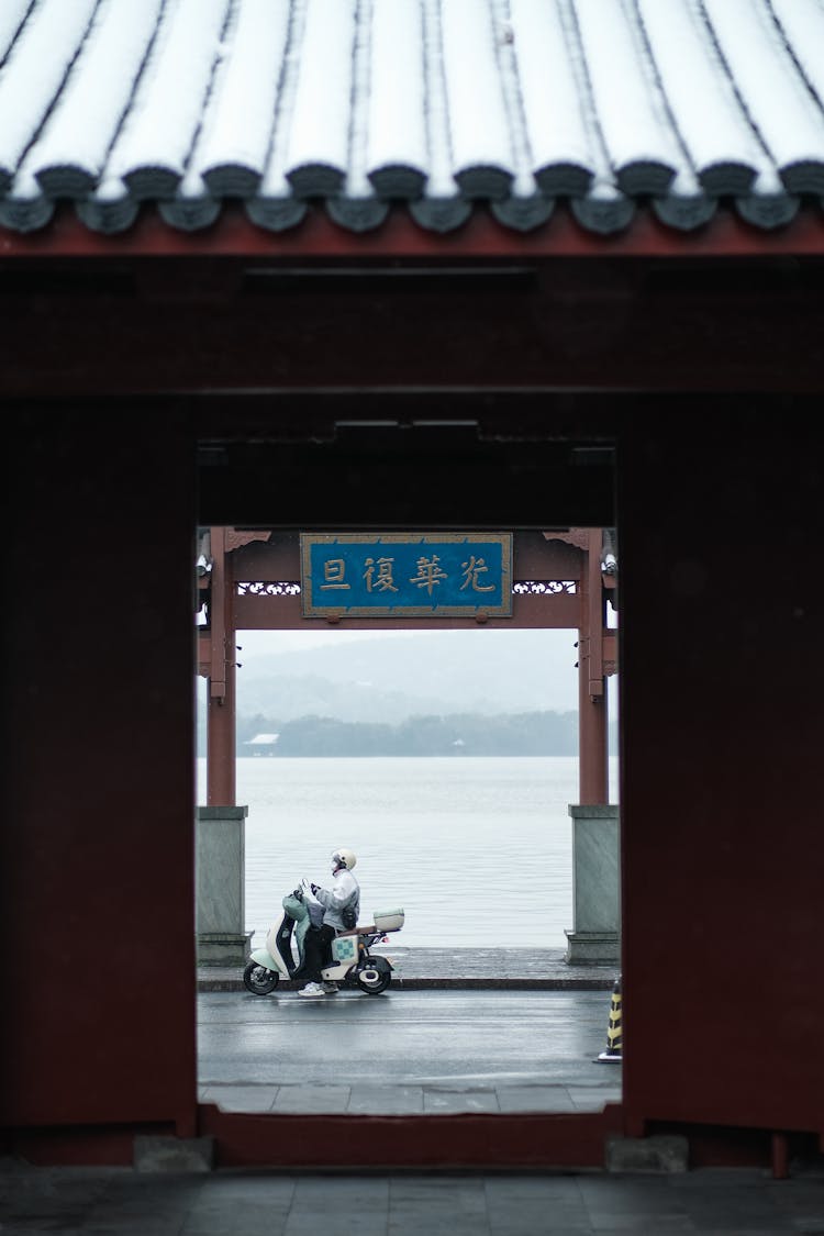 Man On Motorcycle Behind Gate