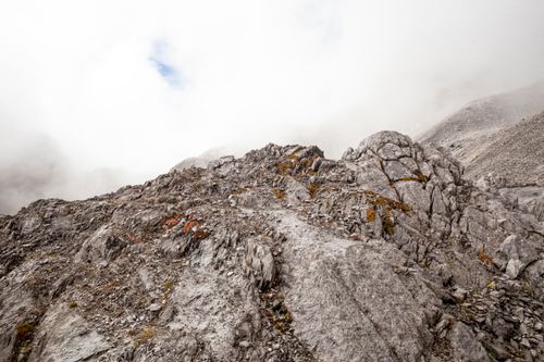 Free Explore rugged mountain terrain shrouded in mist and clouds, showcasing raw nature's beauty. Stock Photo
