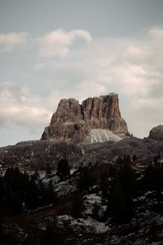 Captivating photograph of Averau Mountain in Veneto, showcasing its rocky majesty under a cloudy sky.