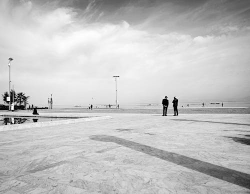 People Walking on Boardwalk near Sea