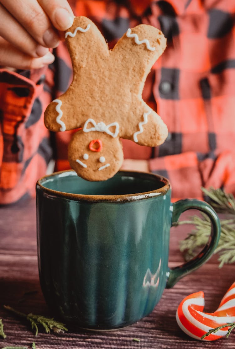 Person Eating Gingerbread Cookie With Tea