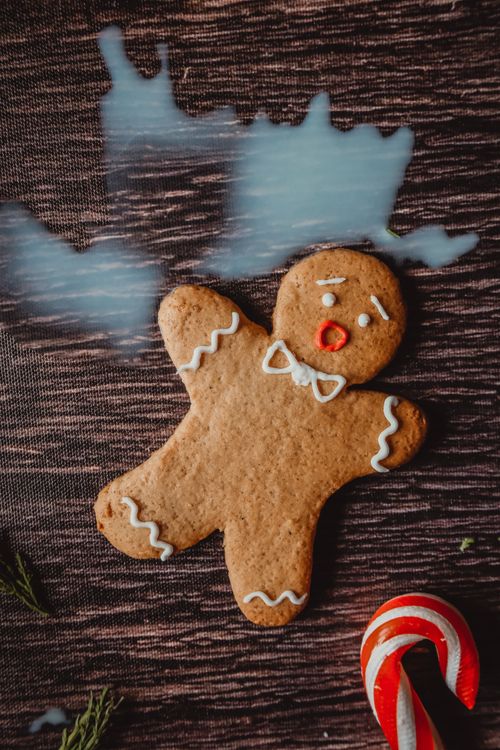Free Cheerful gingerbread man and candy cane on rustic wooden surface, evoking festive holiday vibes. Stock Photo