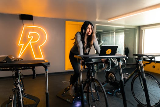 A woman in sportswear exercises on a stationary bike in an indoor gym in Bahrain.