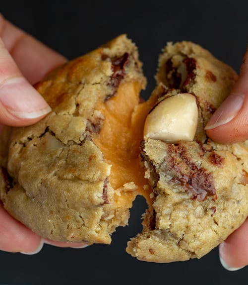 Close-up of Woman Breaking a Cookie in Half 