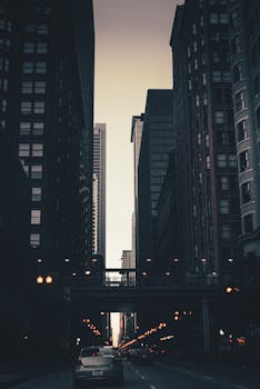 Twilight view of New York City's iconic skyscrapers with streetlights casting a warm glow.