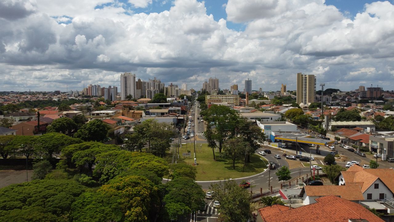 A dynamic aerial view of Londrina, Brazil, showcasing urban cityscape and lush greenery under a dramatic sky.