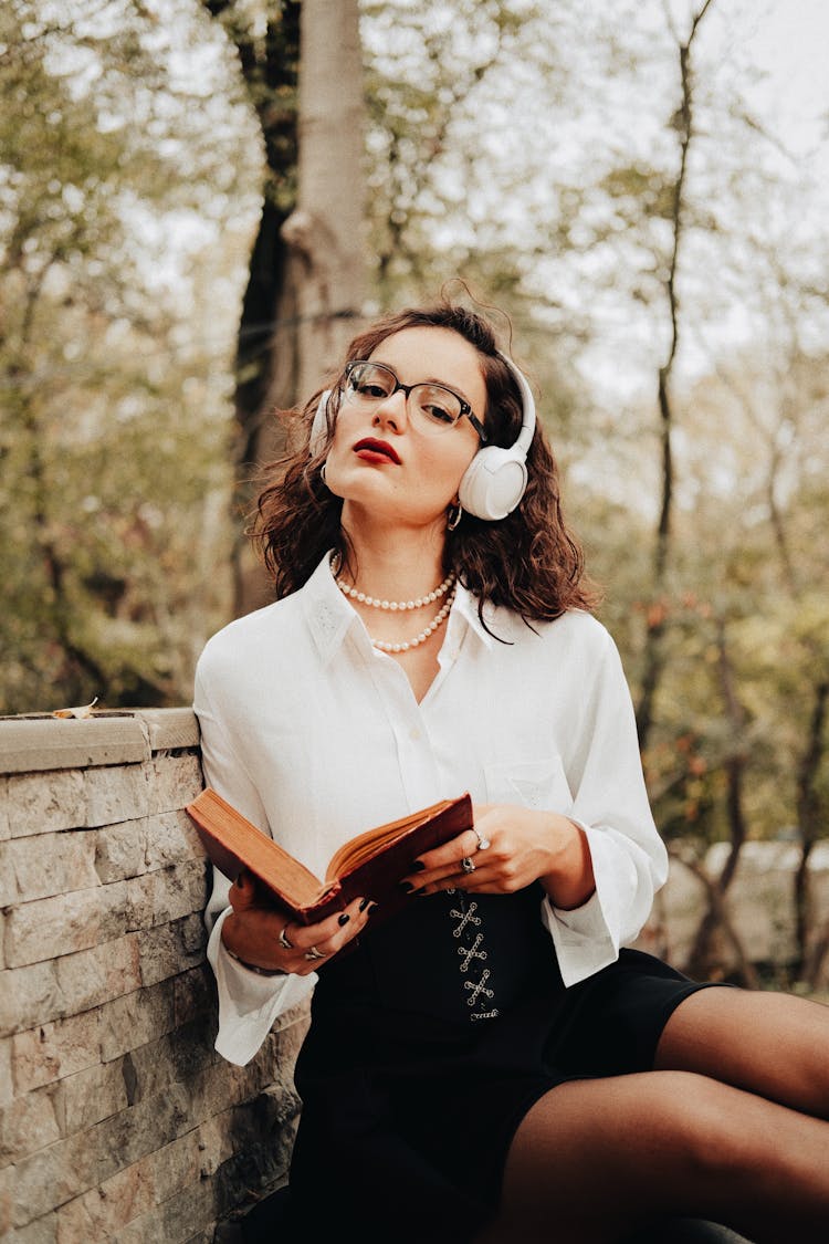 Woman In Headphones Posing With Book