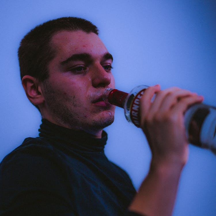 A Man Drinking A Bottle Of Vodka