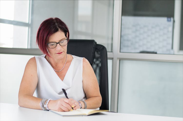 Portrait Of Woman Wearing Eyeglasses Writing