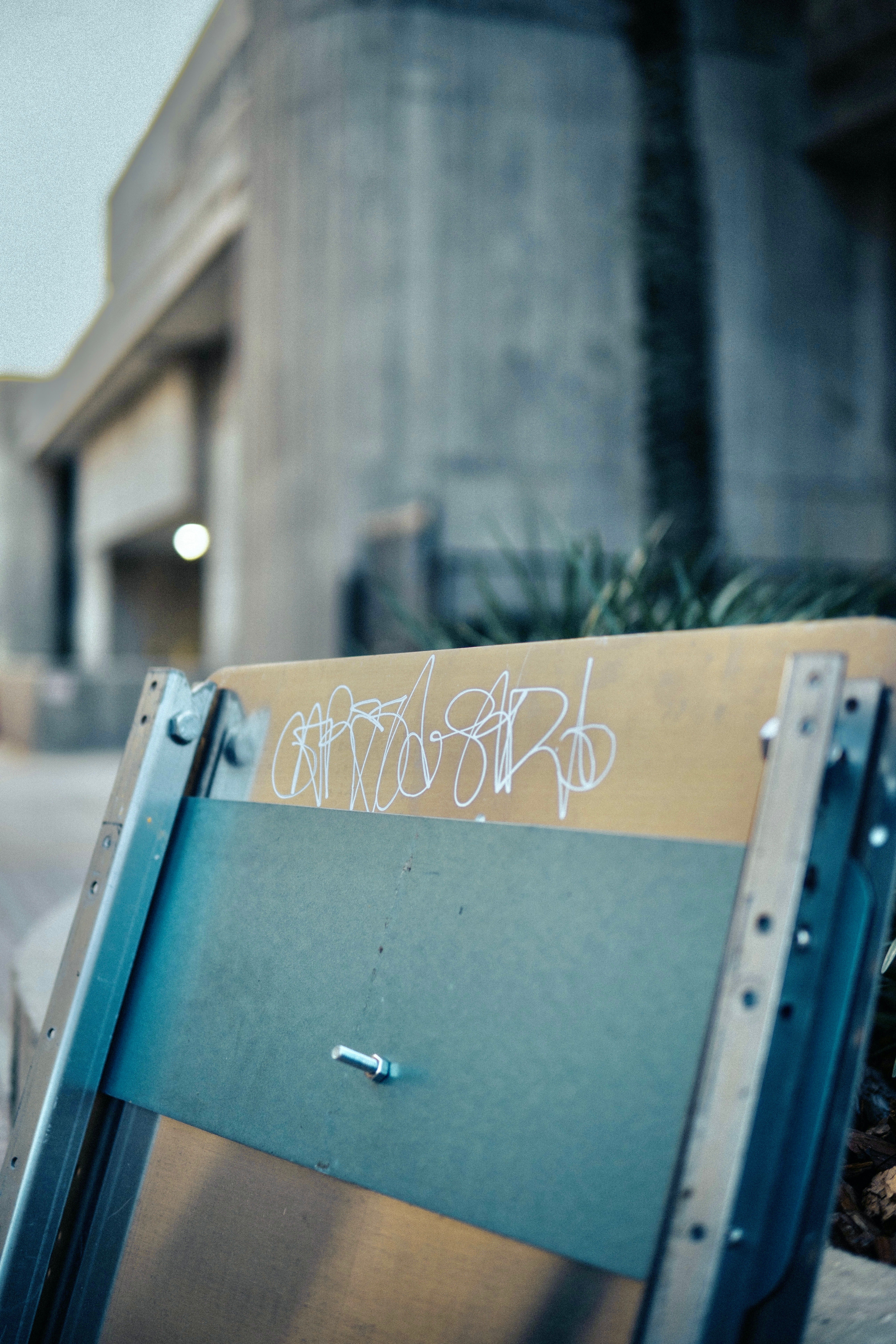 A skateboard with graffiti on it sitting on a sidewalk