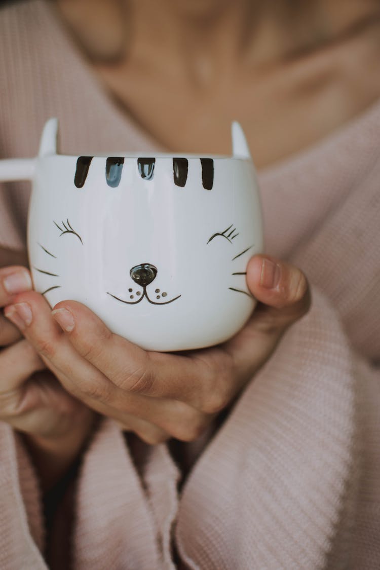 Person Holding White Cat Mug