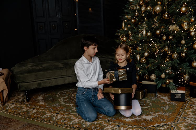 Children Exchanging Gifts By The Christmas Tree