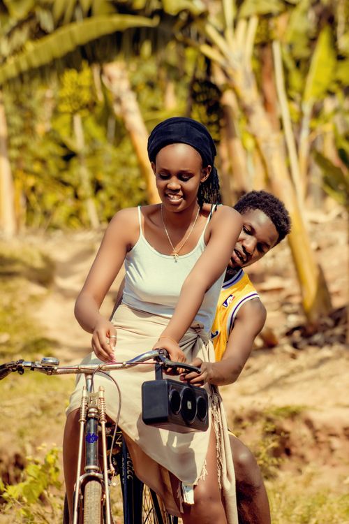 Free Happy couple sharing a joyful bicycle ride in a tropical setting, Kigali, Rwanda. Stock Photo