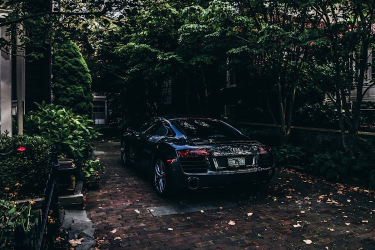 Black Audi Sedan Parked On Pavement Near Trees