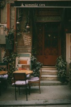 Quaint café entrance in İstanbul adorned with plants and cozy seating.