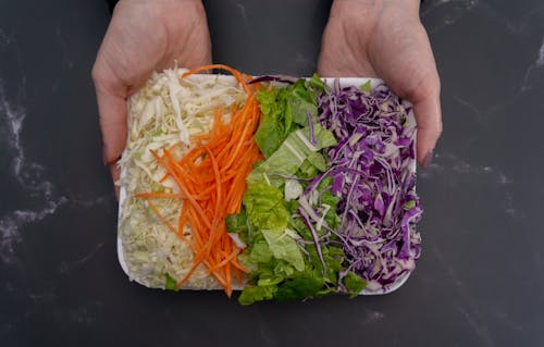 Hands Holding a Tray with Vegetables