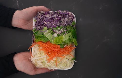 Hands Holding Vegetable Salad 