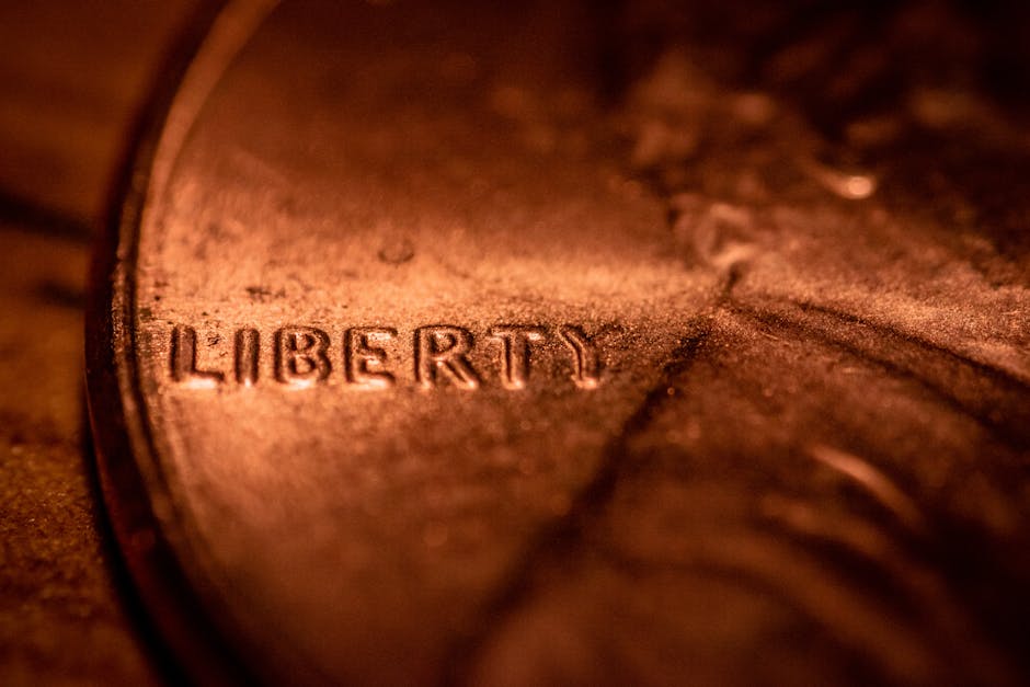 Macro photo of a copper penny highlighting the 'Liberty' inscription, focusing on texture and detail.